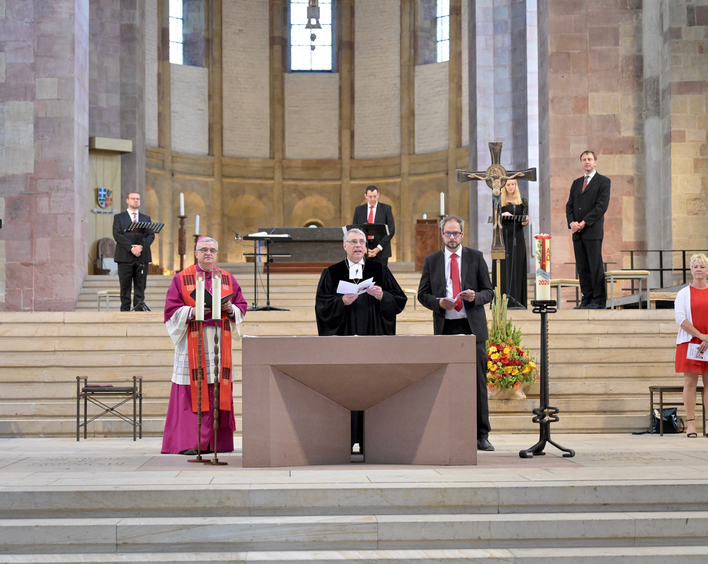 Bischof Wiesemann, Kirchenpräsident Schad, Pastor Wagner und Anja Bein mit dem Vokalensemble im Hintergrund. Foto: lk/Landry