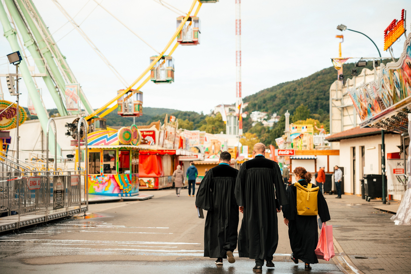 "Im Talar auf dem Wurstmarkt fällt man auf wie ein bunter Hund." Foto: Marius Schiffer/Cambrothers GbR 3 Pfarrer im Talar gehen über einen Rummelplatz