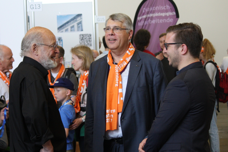 Am Stand der  Evangelischen Akademikerschaft (von links): Vorstandsmitglied Eberhard Hirschler aus Otterstadt stellt Kirchenpräsident Christian Schad und Till Strang die Arbeit vor.