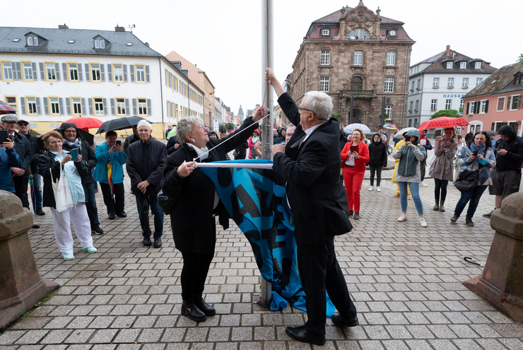 Für Demokratie, gegen Extremismus: Kirchenpräsidentin Wüst und Bischof Wiesemann hissen zum Start der Kampagne "Aufstehen für" eine Flagge vor dem Dom. Foto: Klaus Landry
