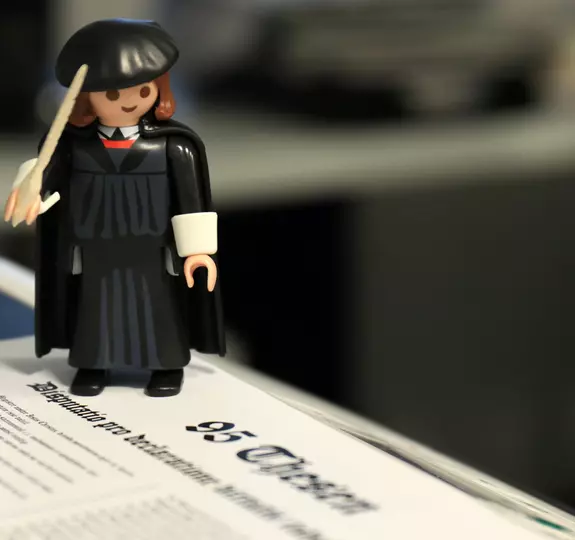 Eine Playmobil-Figur zeigt Martin Luther und die 95 Thesen