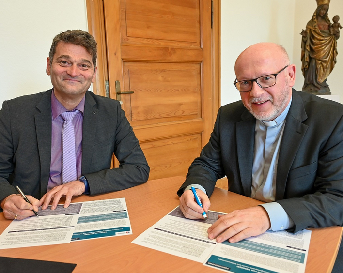Gemeinsamer Einsatz: Oberkirchenrat Markus Jäckle und Generalvikar Markus Magin unterzeichnen das Positionspapier „Es reicht. Mehr Mut zur Suffizienz!“. Foto: Bistum Speyer/Kiese