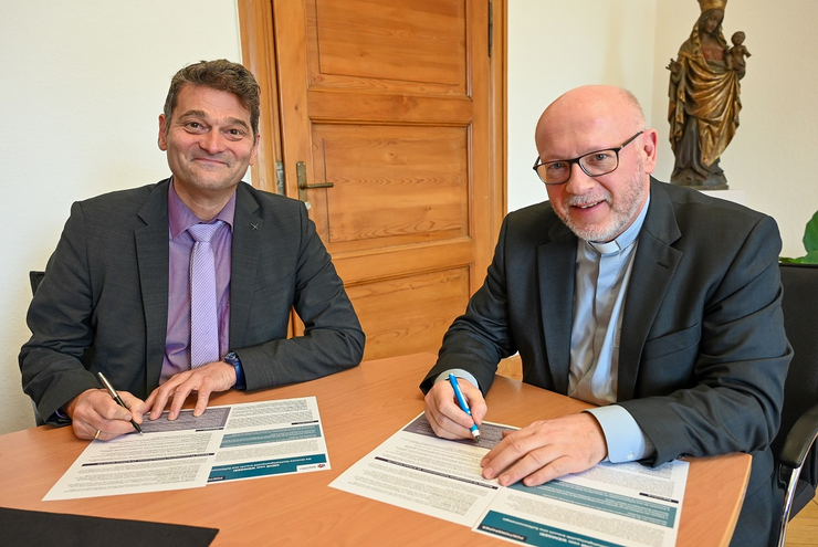 Gemeinsamer Einsatz: Oberkirchenrat Markus Jäckle und Generalvikar Markus Magin unterzeichnen das Positionspapier „Es reicht. Mehr Mut zur Suffizienz!“. Foto: Bistum Speyer/Kiese