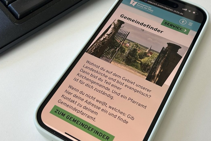 Die neue Website der Landeskirche wird auf einem Smartphonedisplay angezeigt.