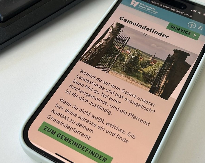 Die neue Website der Landeskirche wird auf einem Smartphonedisplay angezeigt.