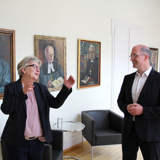 Kirchenpräsidentin Dorothee Wüst und Präses Thorsten Latzel vor der "Ahnengalerie" der pfälzischen Kirchenpräsidenten. Foto: lk/Rummel. Kirchenpräsidentin Dorothee Wüst und Präses Thorsten Latzel vor der "Ahnengalerie" der pfälzischen Kirchenpräsidenten. Foto: lk/Rummel.