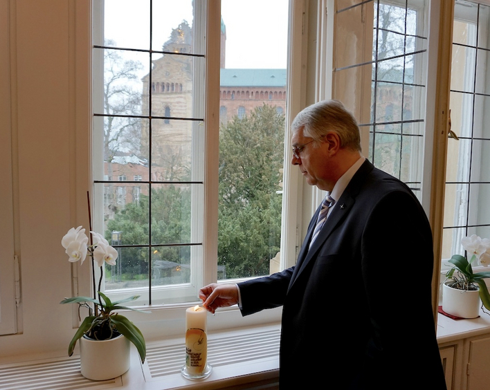 Kirchenpräsident Christian Schad entzündet eine Kerze für #lichtfenster. Foto: lk/Jahn.