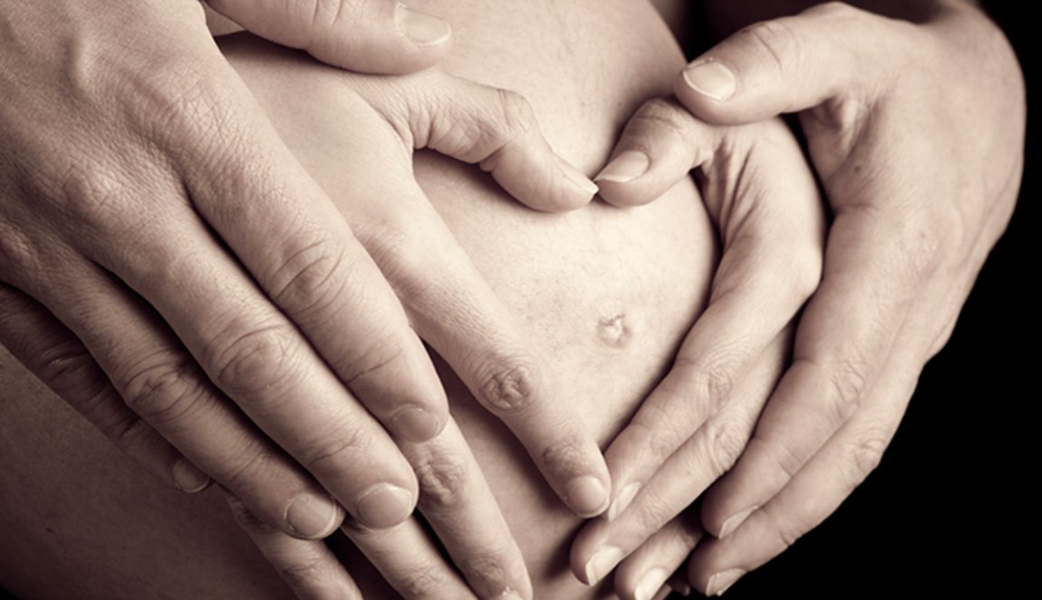Eltern wünschen sich den Segen für ihr ungeborenes Kind.