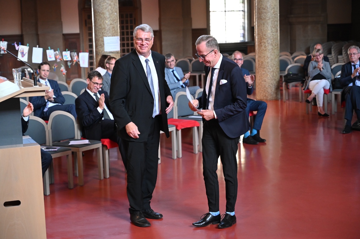 Der Kirchenpräsident Christian Schad gratuliert dem neuen Kirchendiplomaten und langjährigen Pressesprecher Wolfgang Schumacher.
