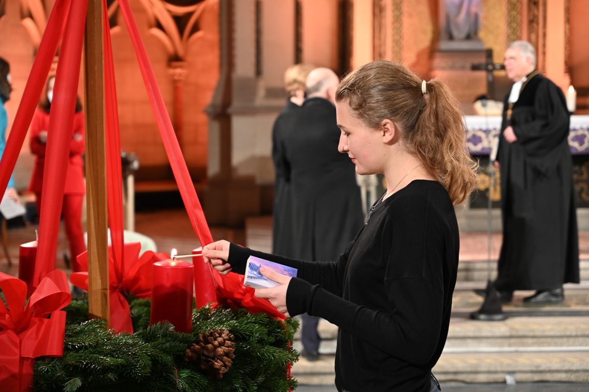 Schülerin Mara Neumayer des Evangelischen Trifelsgymnasiums zündet die erste Kerze an.