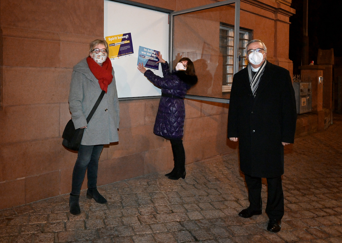 Marina Nikiforova, Geschäftsführerin der Jüdischen Kultusgemeinde der Rheinpfalz (Mitte), hängt mit Oberkirchenrätin Dorothee Wüst (links) und Bischof Karl-Heinz Wiesemann (rechts) erste Plakate zur Aktion #beziehungsweise auf. Foto: lk/Landry.