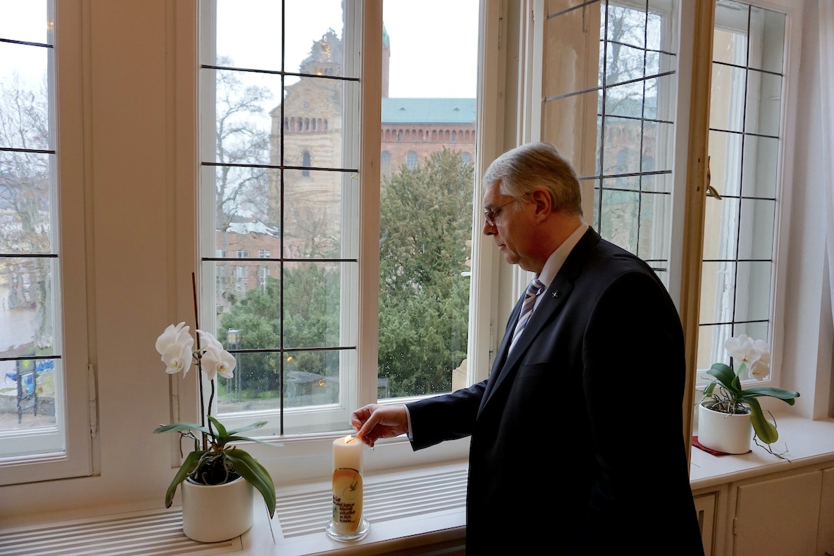 Kirchenpräsident Christian Schad entzündet eine Kerze für #lichtfenster. Foto: lk/Jahn.