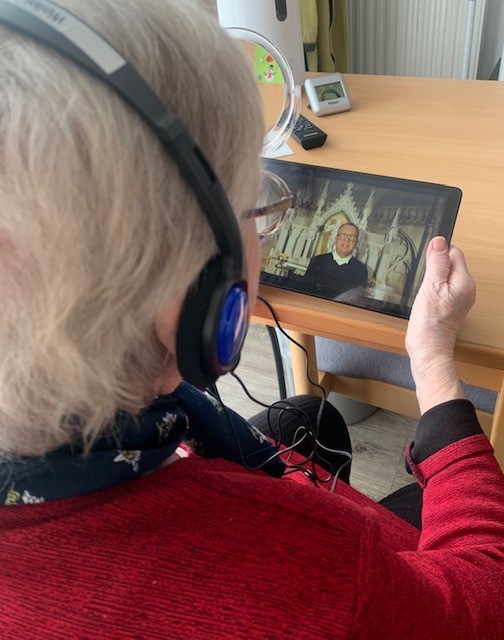 Eine Seniorin schaut eine Video-Andacht auf dem Tablet.