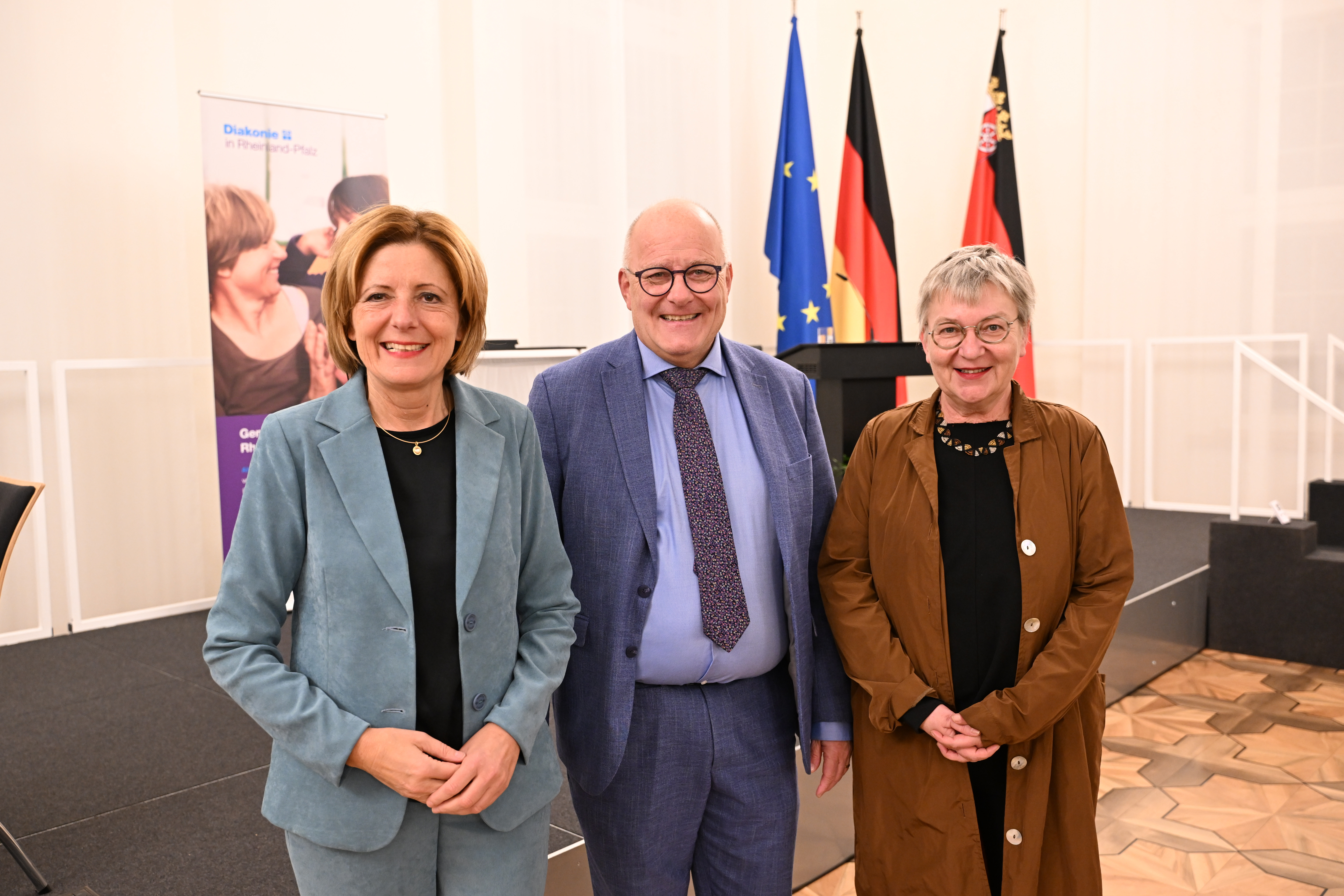 Schirmheerin Malu Dreyer, Jury-Vorsitzende Dorothee Wüst und Landesdiakoniepfarrer Albrecht Bähr bei der Verleihung des Helmut-Simon-Preises. (Foto: Diakonie in Rheinland-Pfalz/Ben Pakalski)