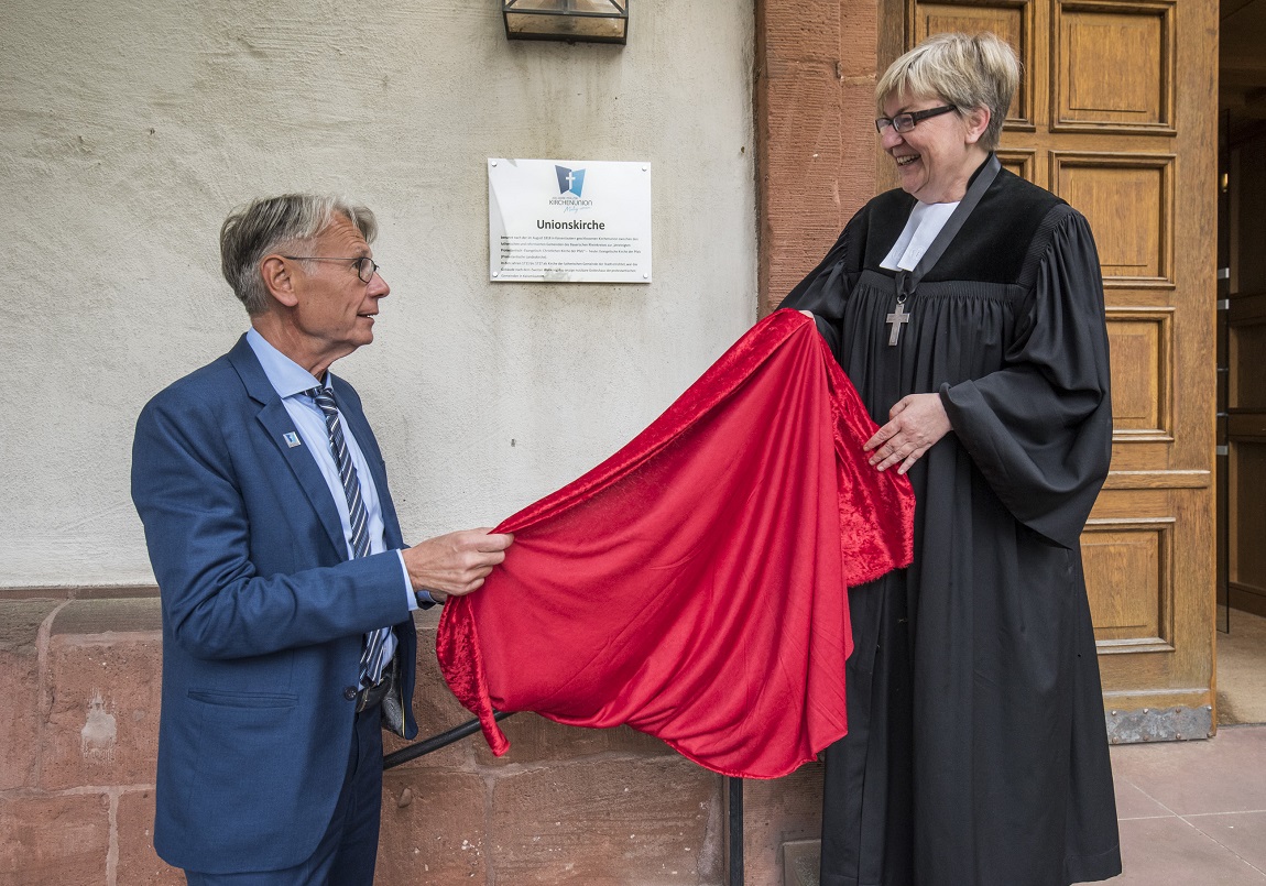 Aus "Kleiner Kirche" wird "Unionskirche": Der Kaiserslauterer Oberbürgermeister Klaus Weichel und Dekanin Dorothee Wüst enthüllen das neue Schild.