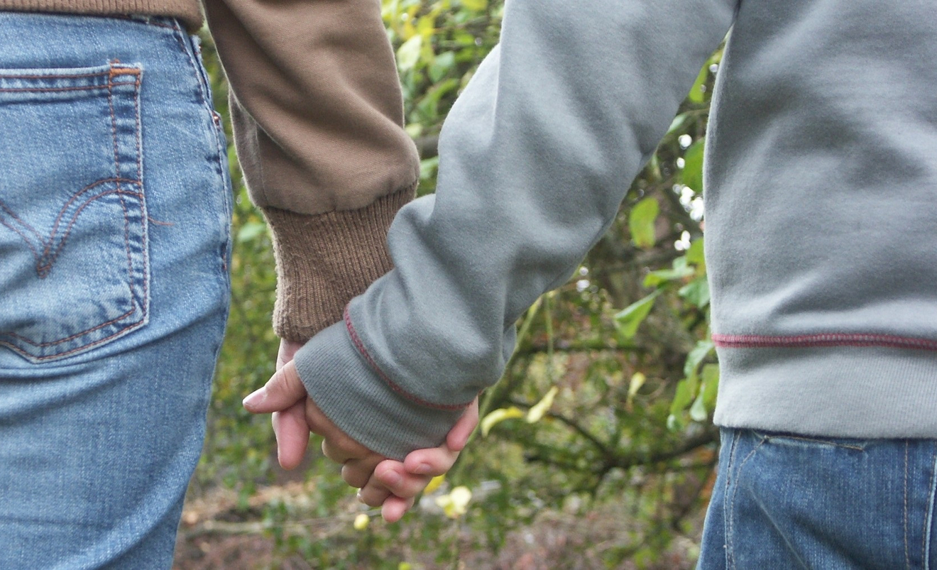 Freunde halten sich die Hand.