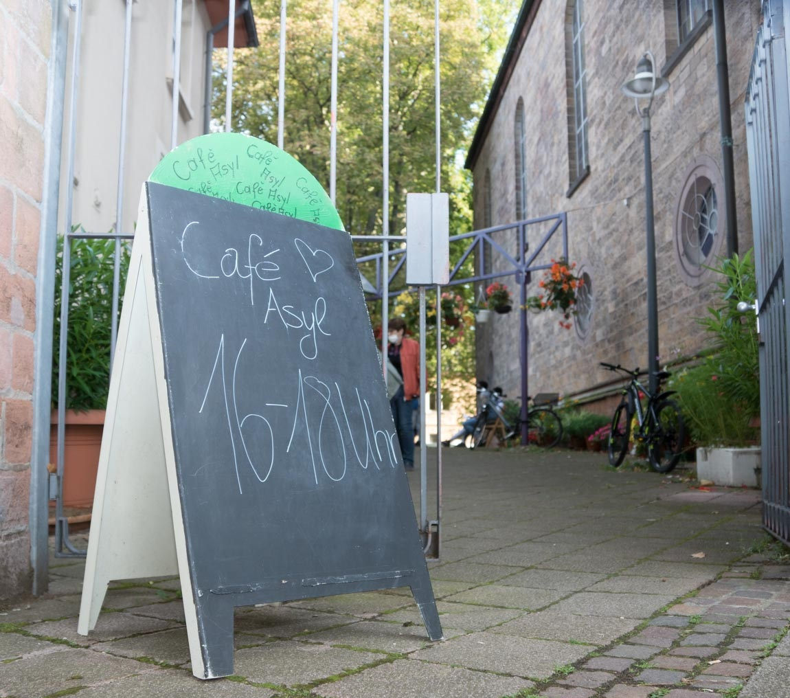 Jeden Dienstag ist Café-Zeit: Café Asyl an der Protestantischen Christus-Kirchengemeinde läd mit einem Schild zum Kommen ein.