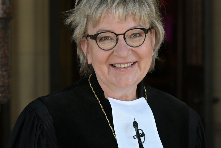 Eine Frau im Talar und Kreuz