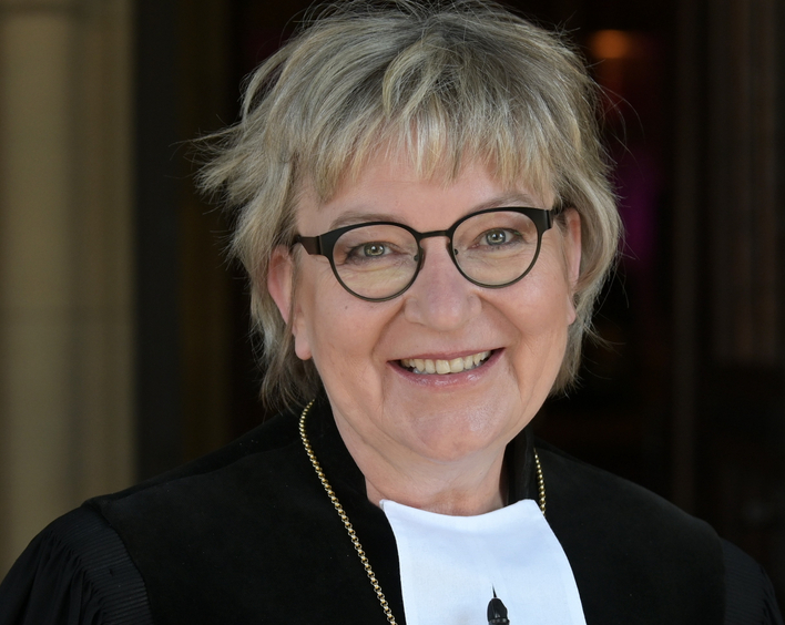 Eine Frau mit Brille im Talar mit dem Amtskreuz der Kirchenpärsidentin