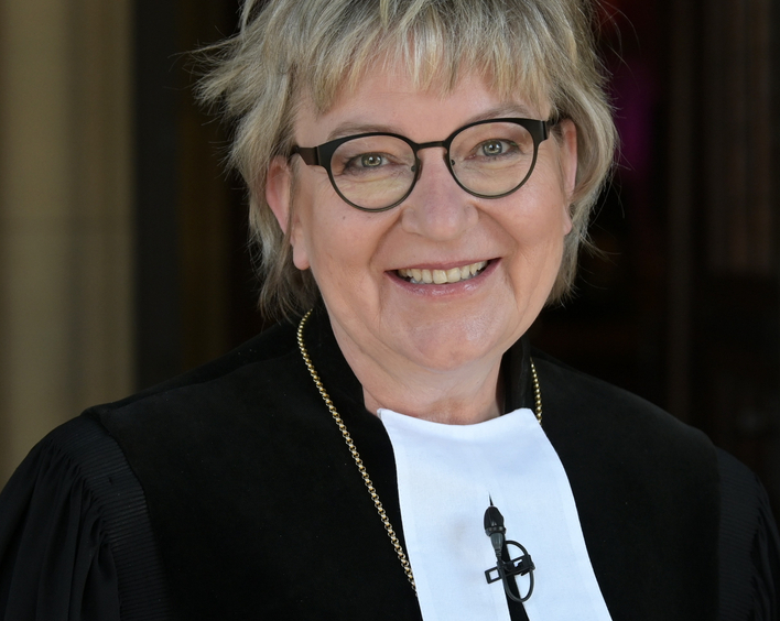 Eine Frau im Talar und Kreuz