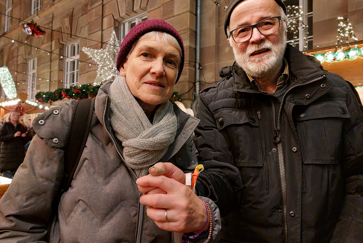 Mary und Werner Kunz: An der Pyramide auf dem Speyerer Weihnachtsmarkt ließen sie sich den Weihnachtssegen und Segensbändchen für das Handgelenk geben. Foto: Lore Dohrenbusch