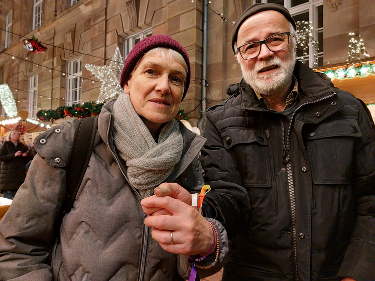 Mary und Werner Kunz: An der Pyramide auf dem Speyerer Weihnachtsmarkt ließen sie sich den Weihnachtssegen und Segensbändchen für das Handgelenk geben. Foto: Lore Dohrenbusch