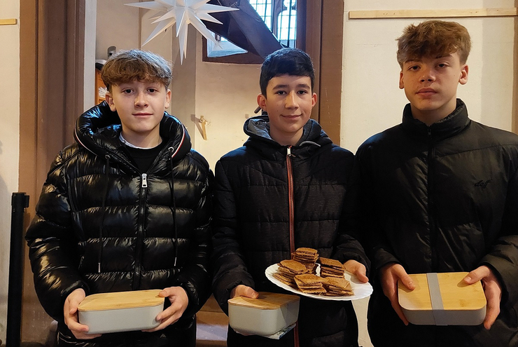 Die Konfirmanden Maik, Vincent und Louis bieten Zimtwaffeln an. Foto: lk Dohrenbusch
