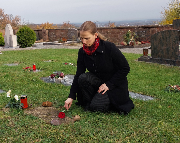 Erfüllt den Wunsch einer Angehörigen: Pfarrerin Jutta Fang legt auf dem Friedhof eine Rose aufs Urnengrab. Foto: Dohrenbusch